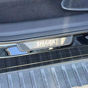 Black SHARK branded protective trim plate installed on a vehicle bumper.