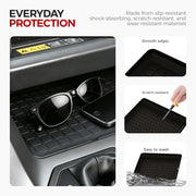 Black slip-resistant rubber car console tray protecting sunglasses and a phone.