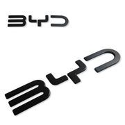 Two black glossy BYD car emblems on a white background.