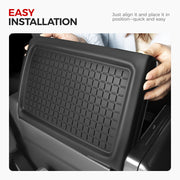 Person installing a black textured protective mat into a vehicle interior compartment.