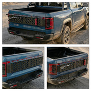 Blue 4x4 pickup truck featuring a black modular tailgate organizer and off-road accessories.