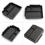 Black plastic vehicle center console organizer tray with multiple compartments.